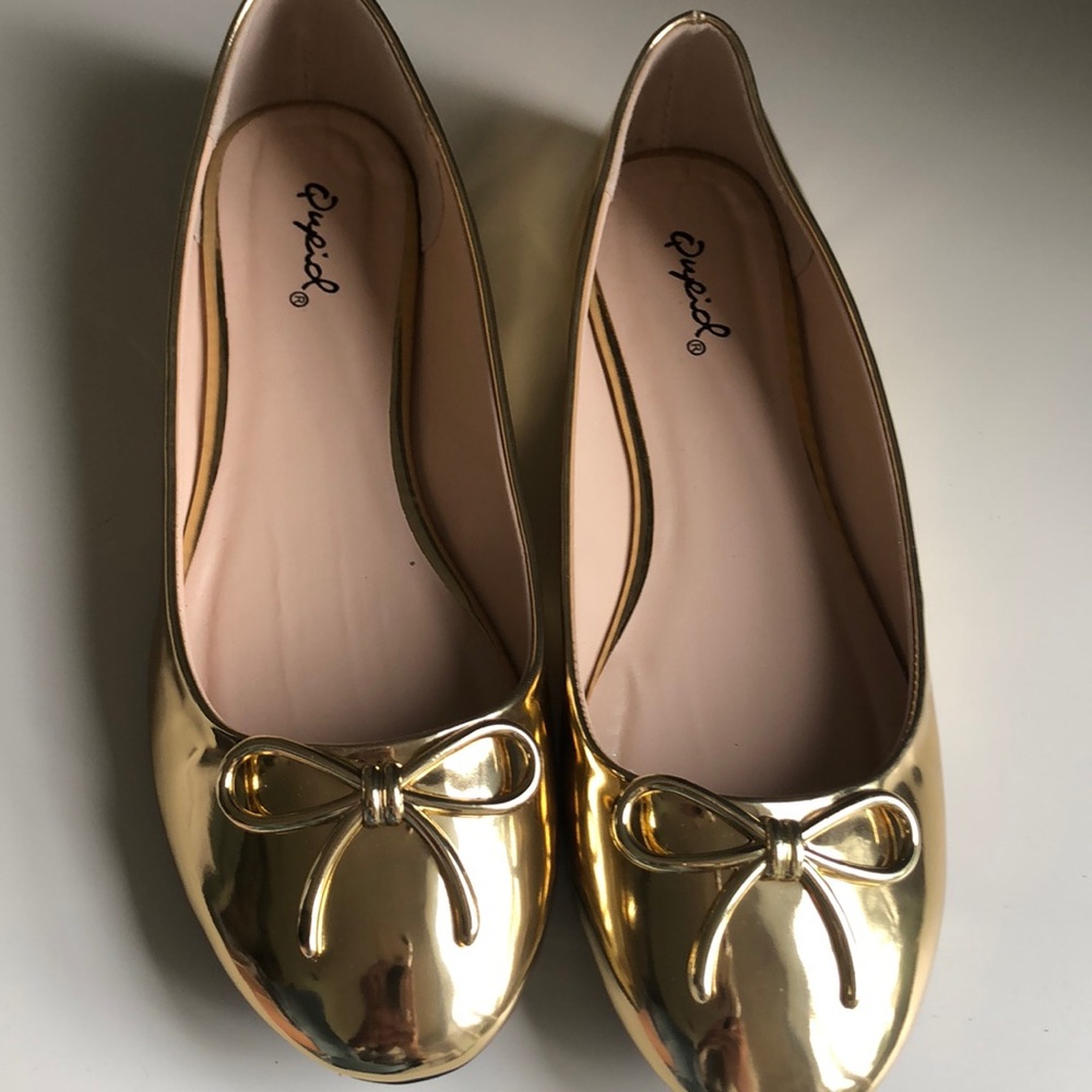 Gold flat shoes.